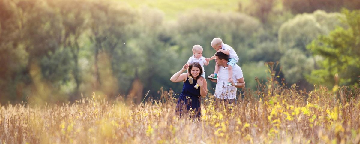 A family with two children runs through a field in the district of Kitzingen am Main