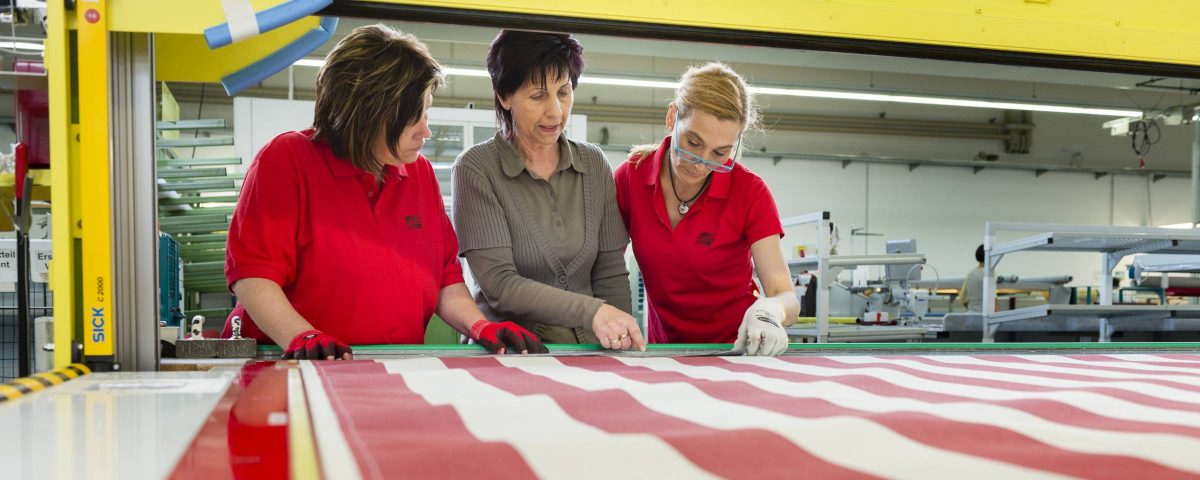 Drei Mitarbeitende in roter Arbeitskleidung im Landkreis Main-Spessart