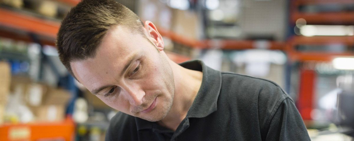 an employee in black shirt concentrating on his work