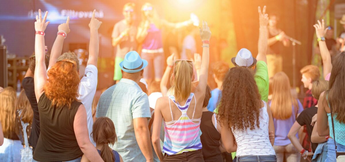 mehrere Menschen genießen ein Konzert an einem warmen Sommertag in Mainfranken