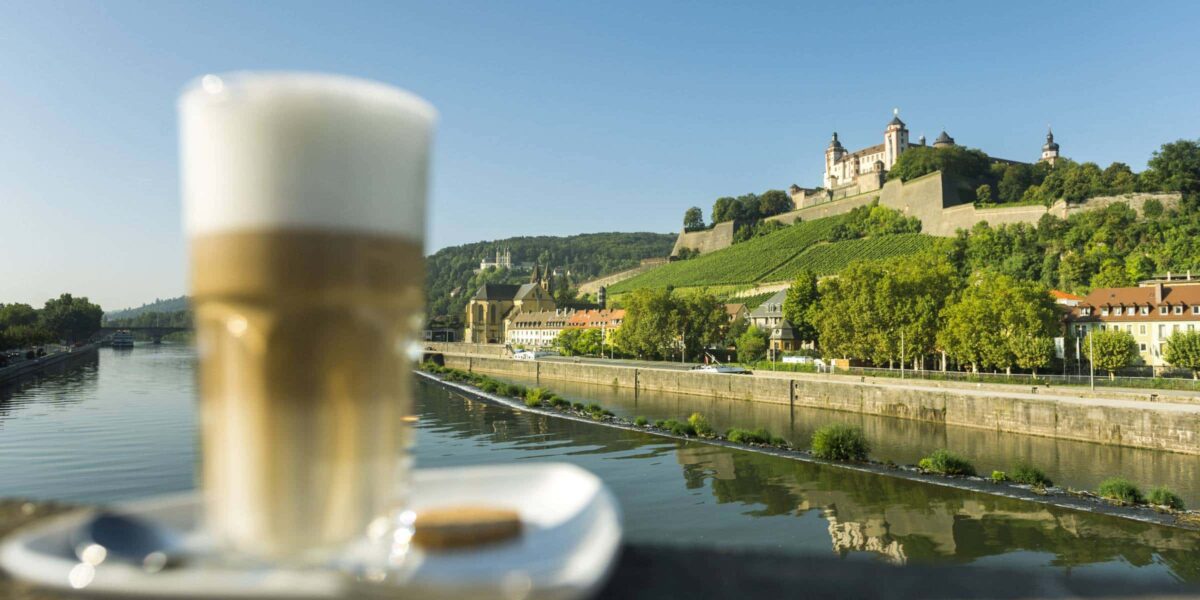 Kaffee im Vordergrund, im Hintergrund der Main und die Festung i Würzburg