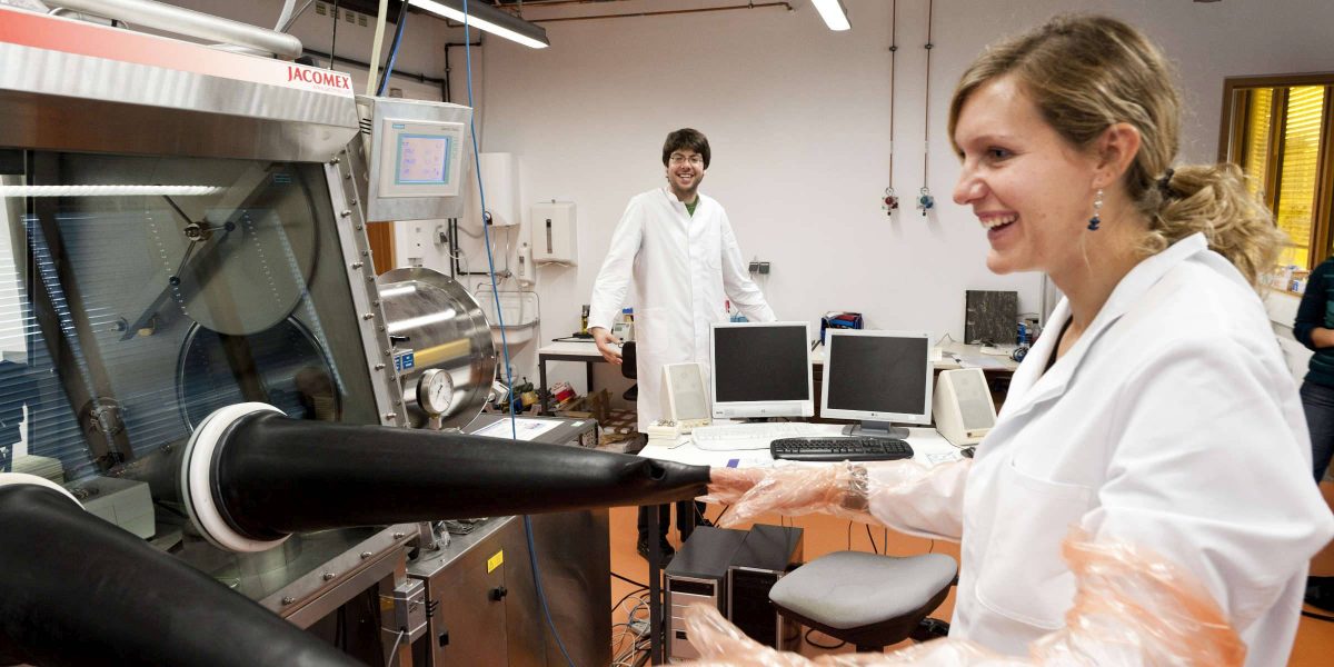 zwei Forschende in weißem Kittel am Forschen an einer Maschine beim Zentrum für angewandte Energieforschung