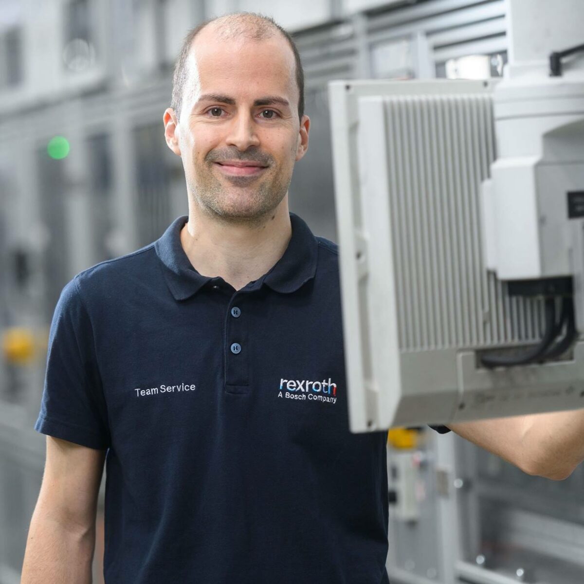 Mitarbeiter mit blauen Oberteil an einem Bildschirm von Bosch rexroth